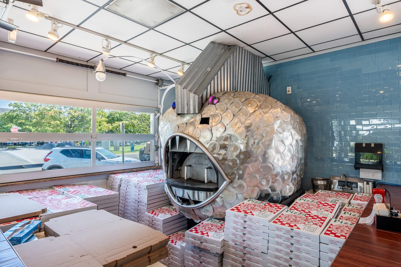 The domed pizza oven behind the counter, boxes stacked ready for service.