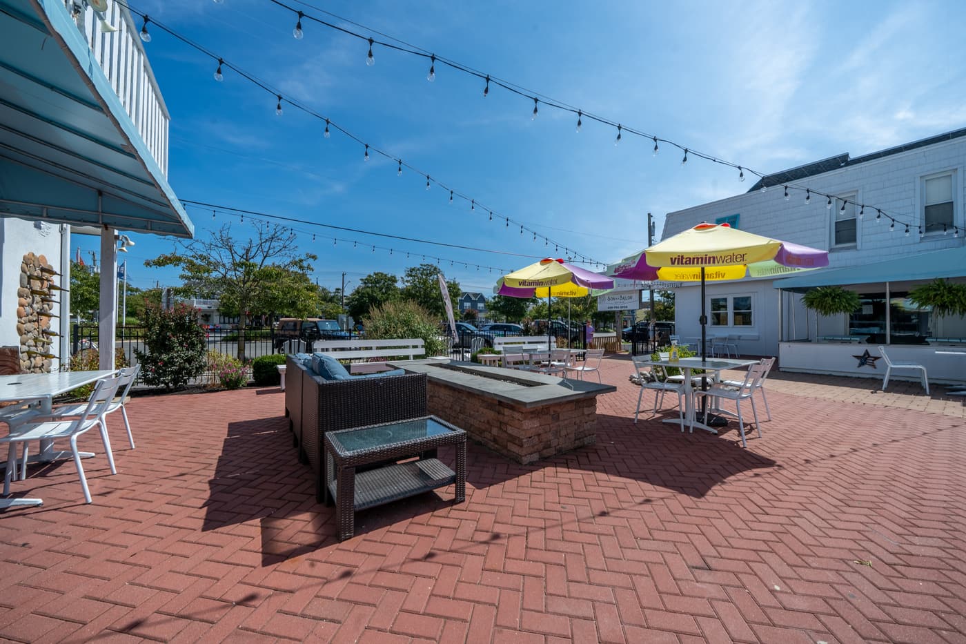 The brick-paved patio with umbrella tables and string lights.