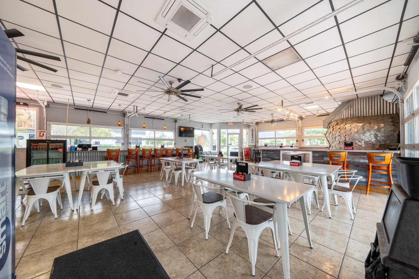 The dining room under a high pressed ceiling with ceiling fans.